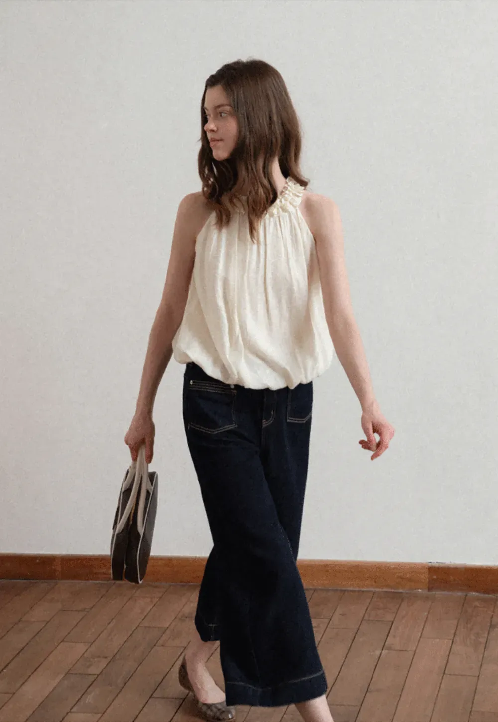 Sleeveless blouse with ruffled neckline and pleats