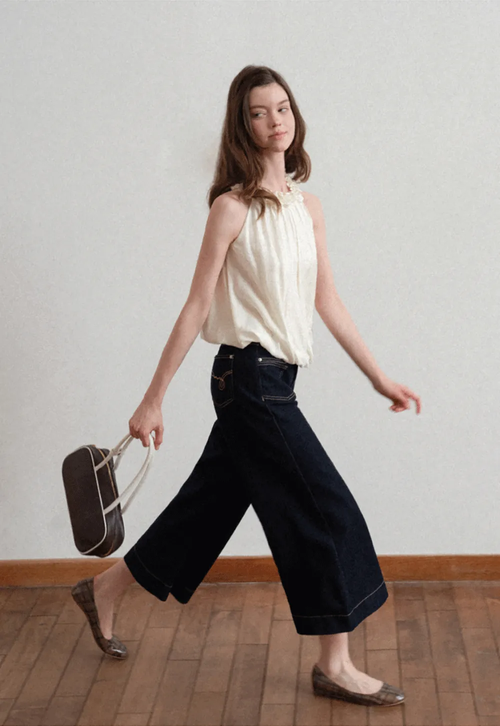 Sleeveless blouse with ruffled neckline and pleats