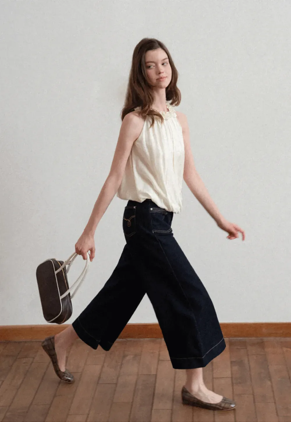 Sleeveless blouse with ruffled neckline and pleats
