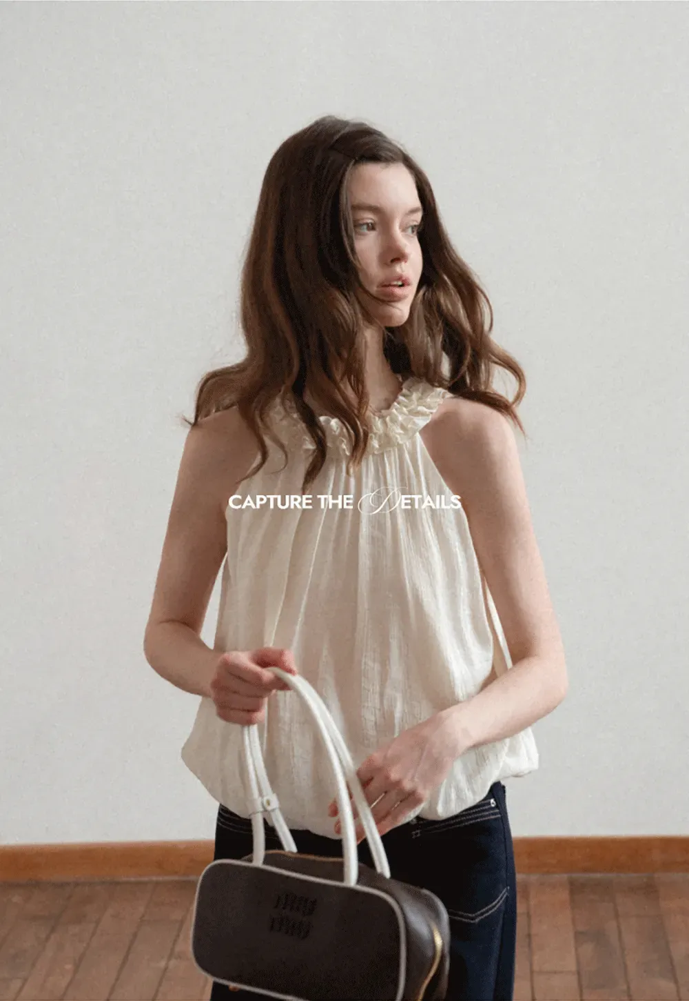 Sleeveless blouse with ruffled neckline and pleats