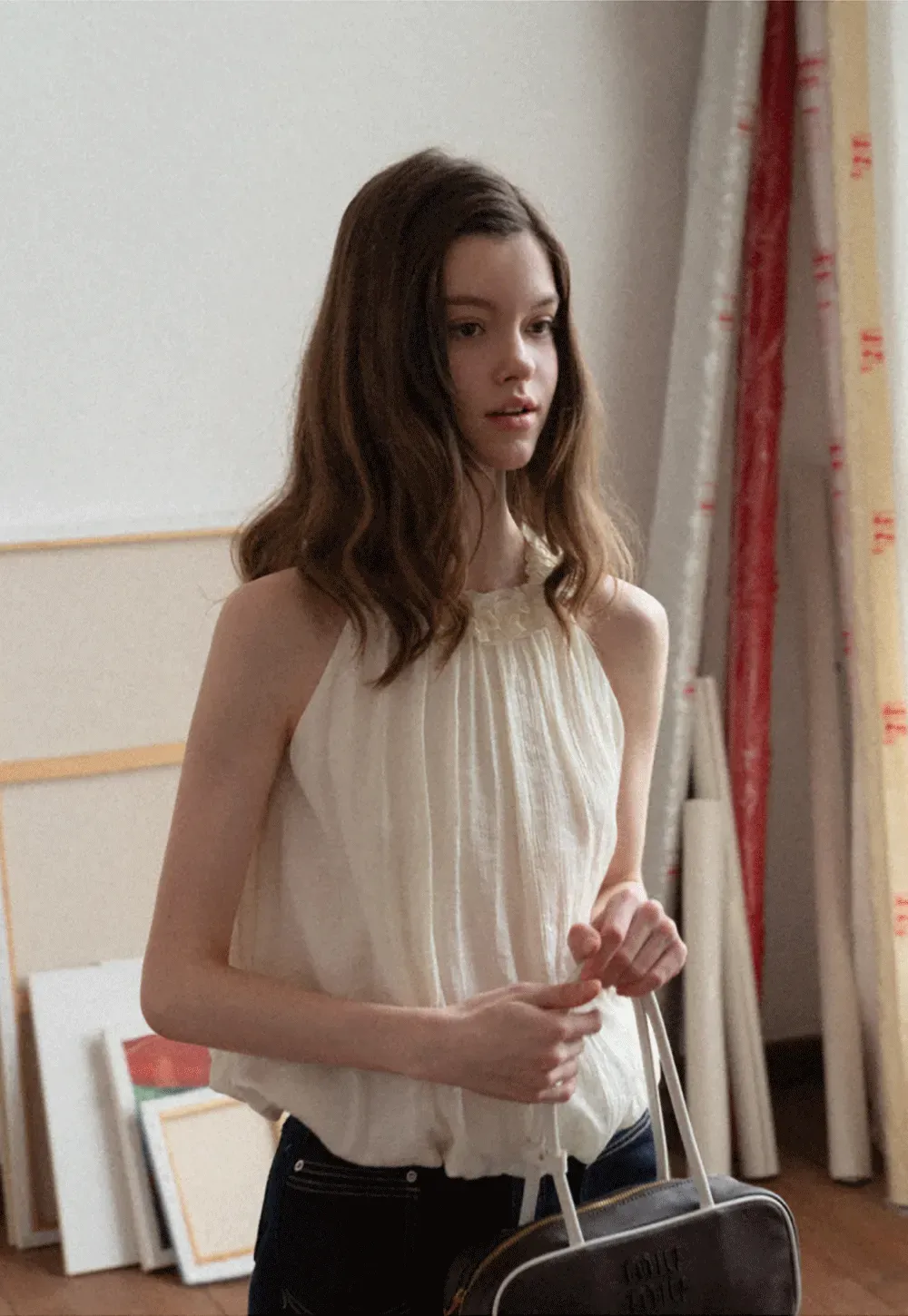 Sleeveless blouse with ruffled neckline and pleats