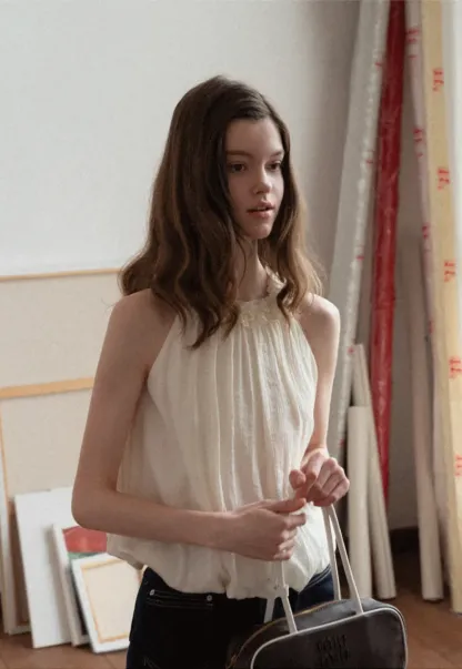 Sleeveless blouse with ruffled neckline and pleats