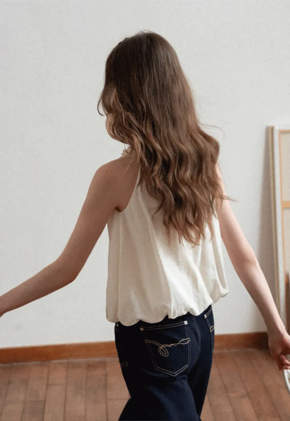 Sleeveless blouse with ruffled neckline and pleats