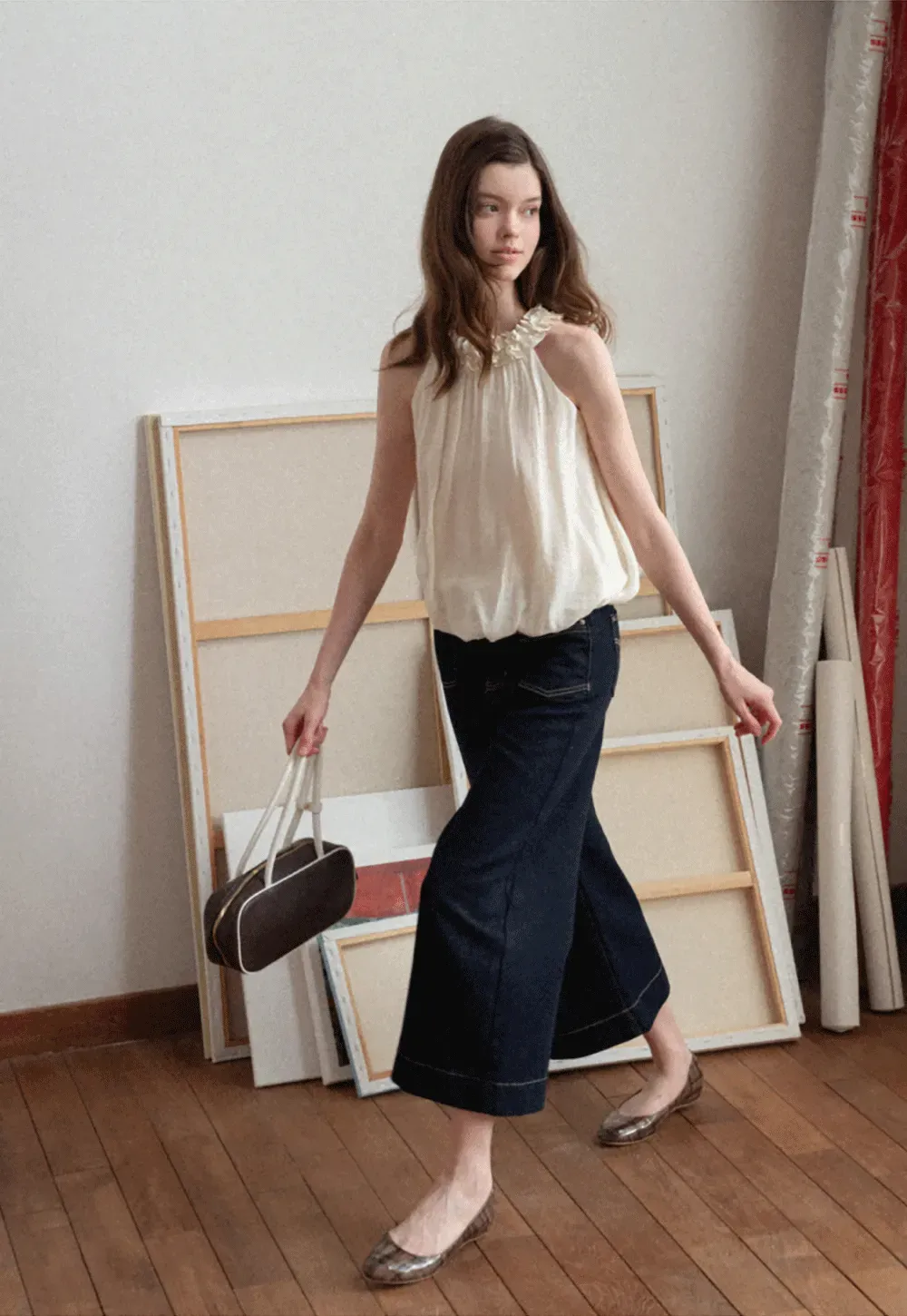 Sleeveless blouse with ruffled neckline and pleats