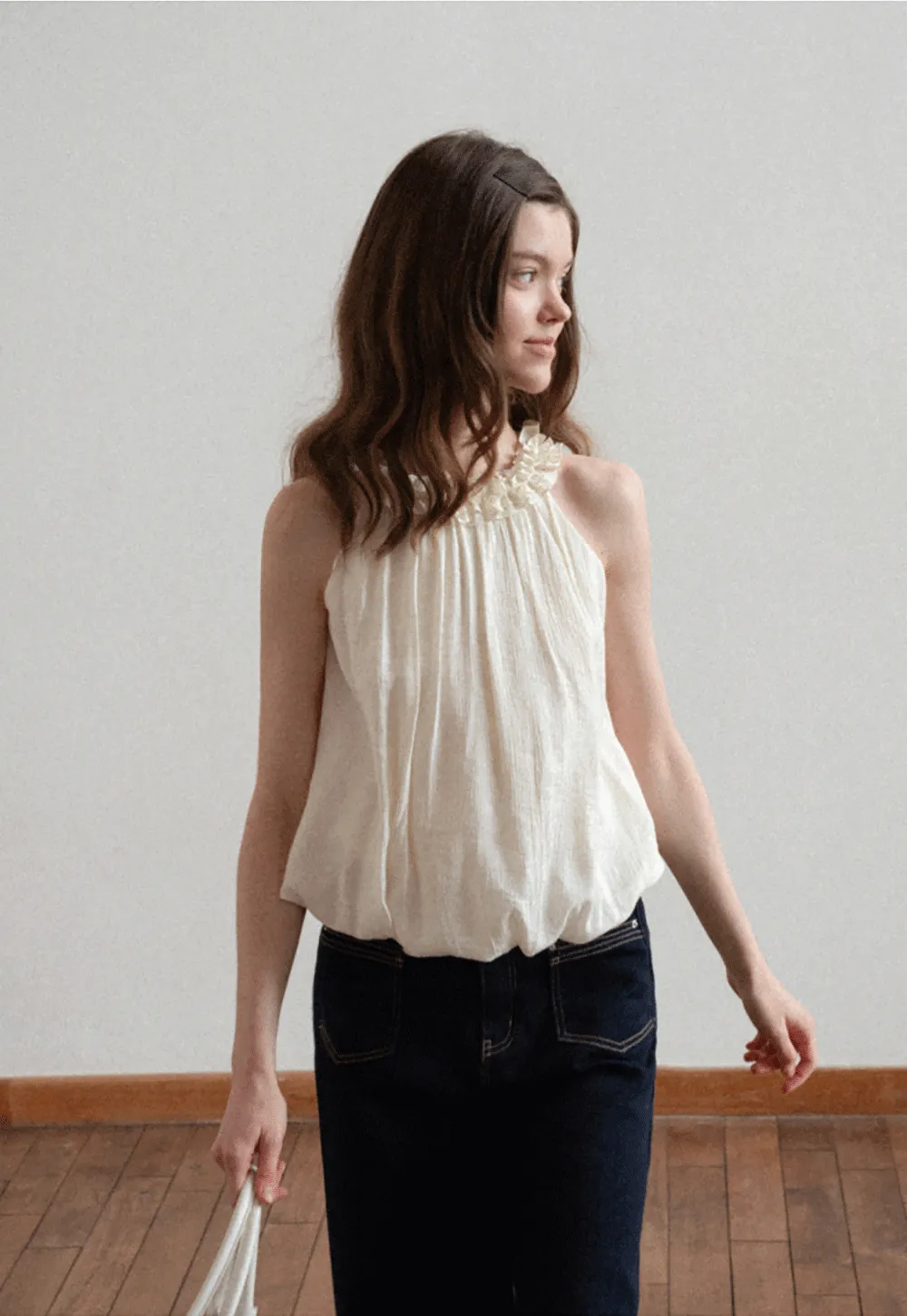 Sleeveless blouse with ruffled neckline and pleats