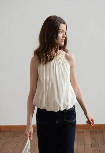 Sleeveless blouse with ruffled neckline and pleats