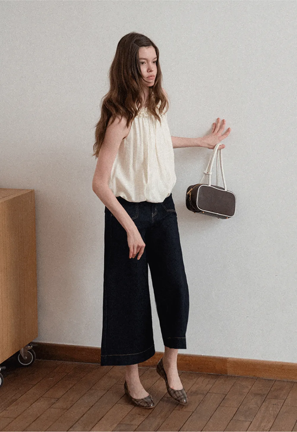 Sleeveless blouse with ruffled neckline and pleats