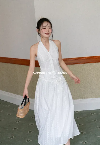 Halter neck sleeveless top with buttons and pleated skirt