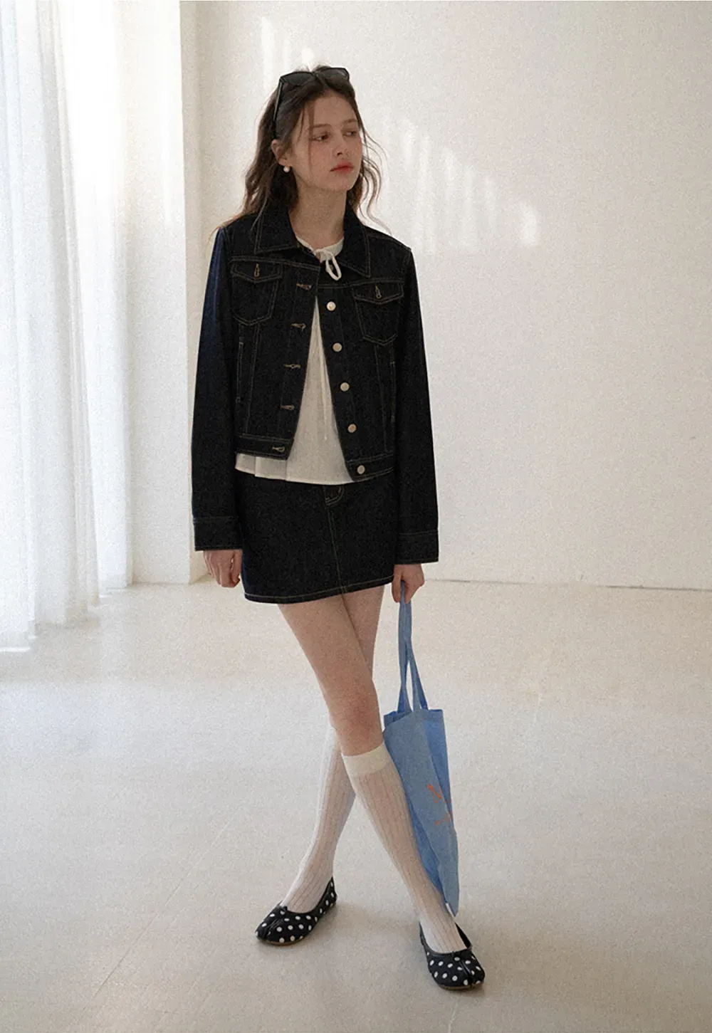 A-line denim skirt with front pocket design and adjustable waistband.