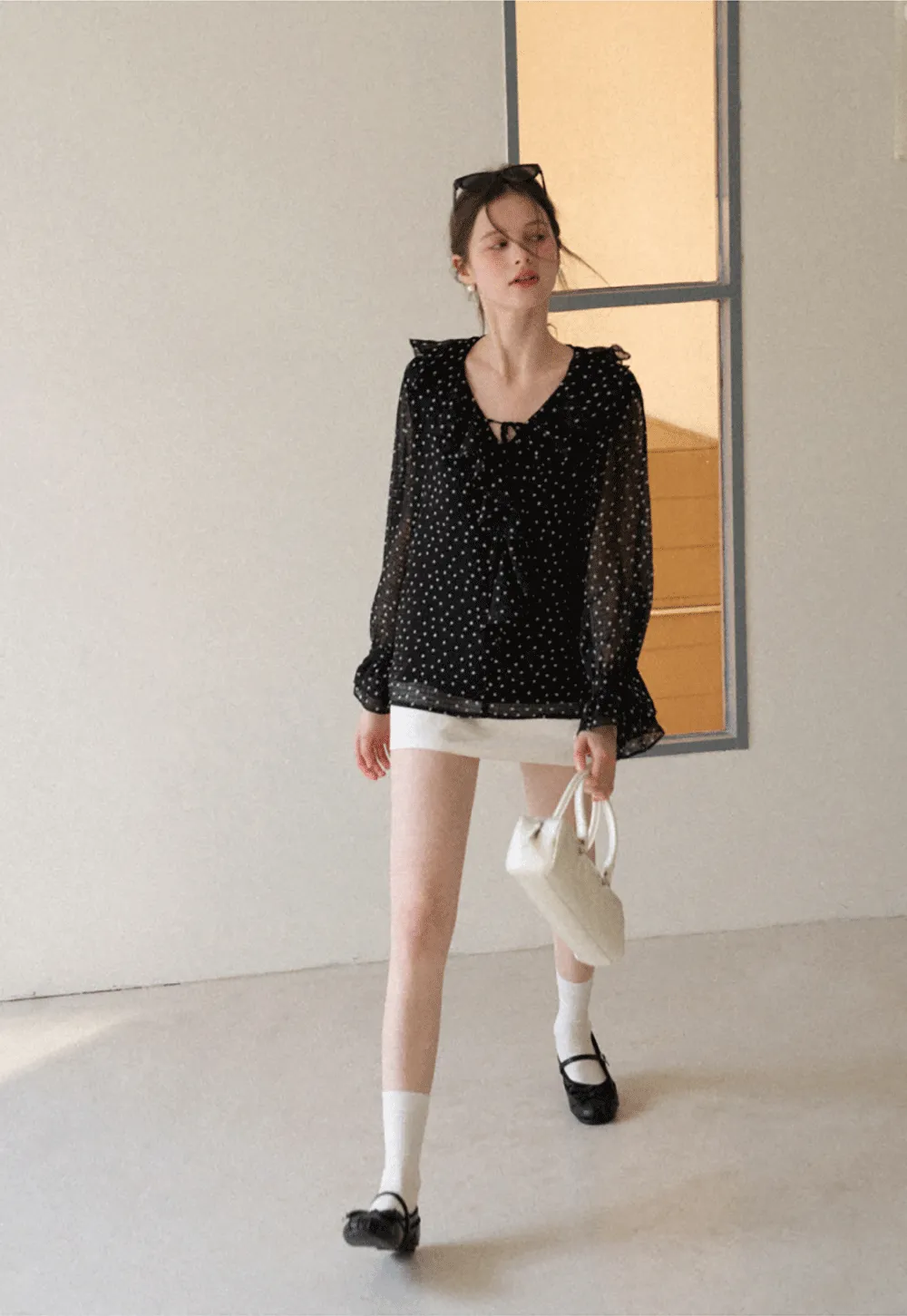 Sheer polka dot blouse with ruffled neckline and long sleeves