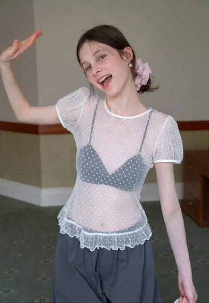 Sheer polka dot top with ruffled hem and puff sleeves