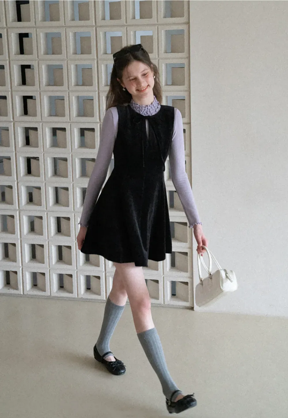 Elegant sleeveless dress with ruffled collar and bow tie design