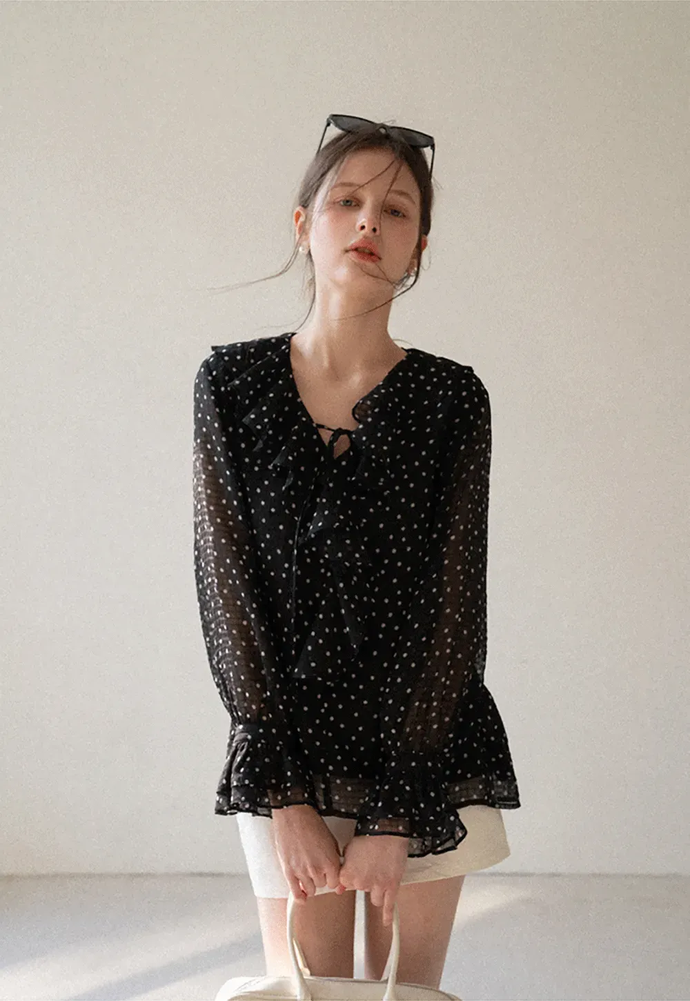 Sheer polka dot blouse with ruffled neckline and long sleeves