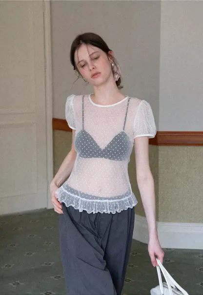 Sheer polka dot top with ruffled hem and puff sleeves
