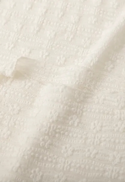 Elegant textured long sleeve top with subtle pattern design