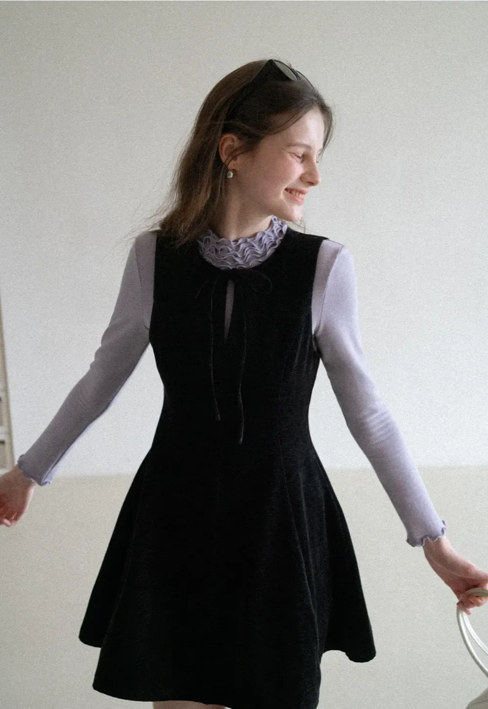 Elegant sleeveless dress with ruffled collar and bow tie design