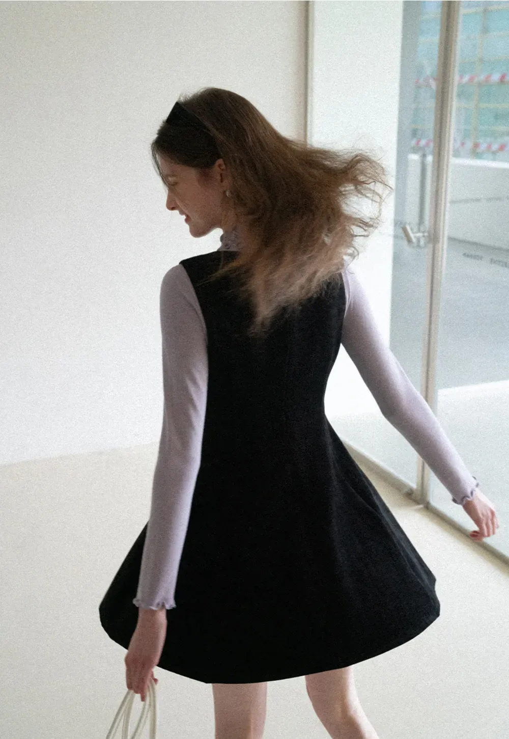 Elegant sleeveless dress with ruffled collar and bow tie design