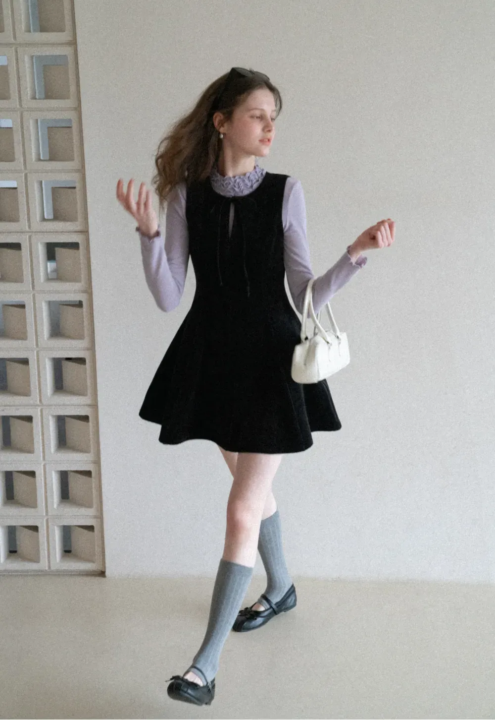 Elegant sleeveless dress with ruffled collar and bow tie design