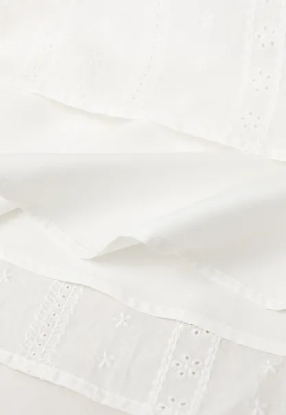 Halter neck sleeveless top with buttons and pleated skirt