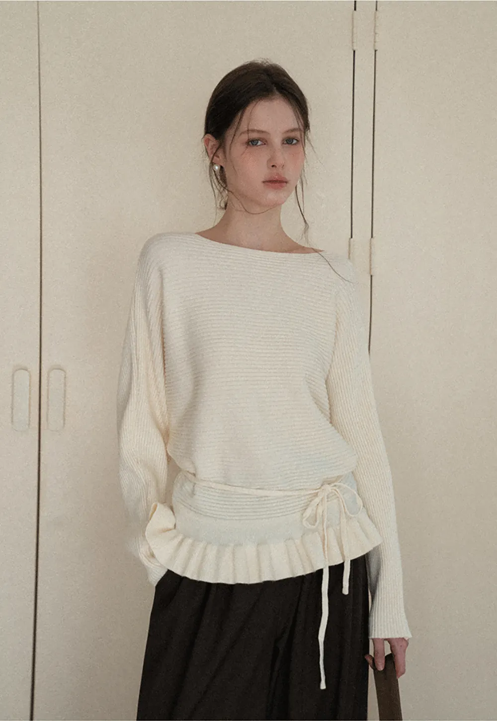 Ribbed knit sweater with tie back and flared hem design