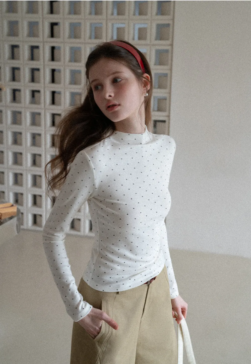 Elegant sleeveless dress with collar layered over polka dot top