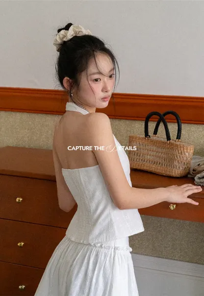 Halter neck sleeveless top with buttons and pleated skirt