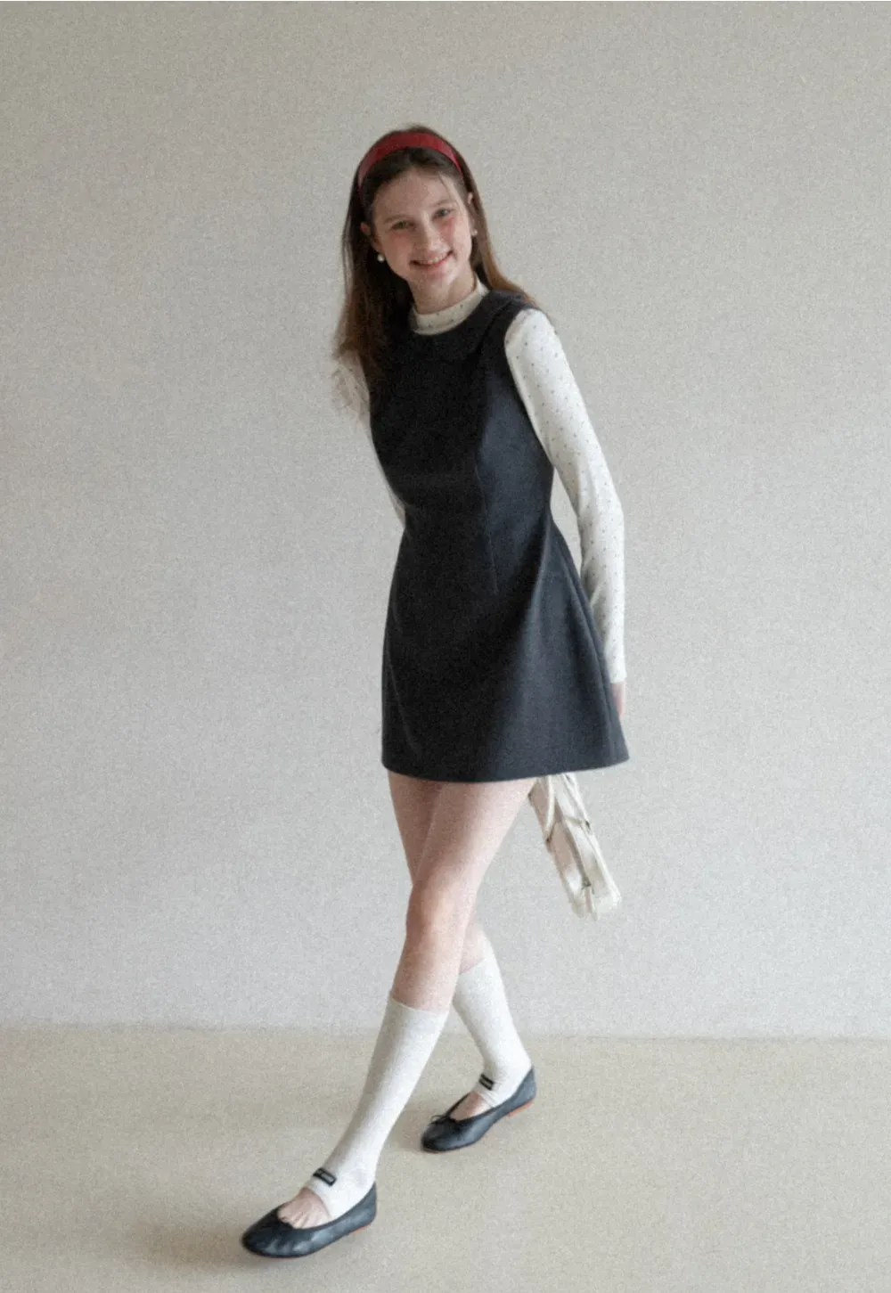 Elegant sleeveless dress with collar layered over polka dot top