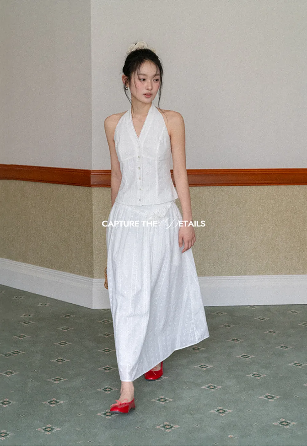 Halter neck sleeveless top with buttons and pleated skirt