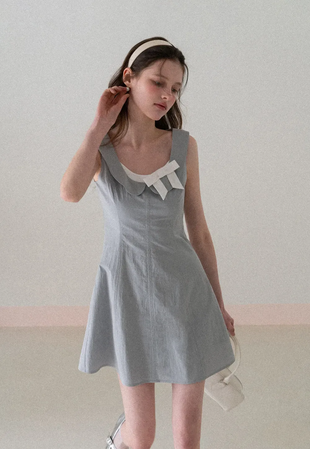 Sleeveless dress with Peter Pan collar and bow detail