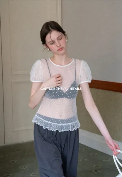 Sheer polka dot top with ruffled hem and puff sleeves