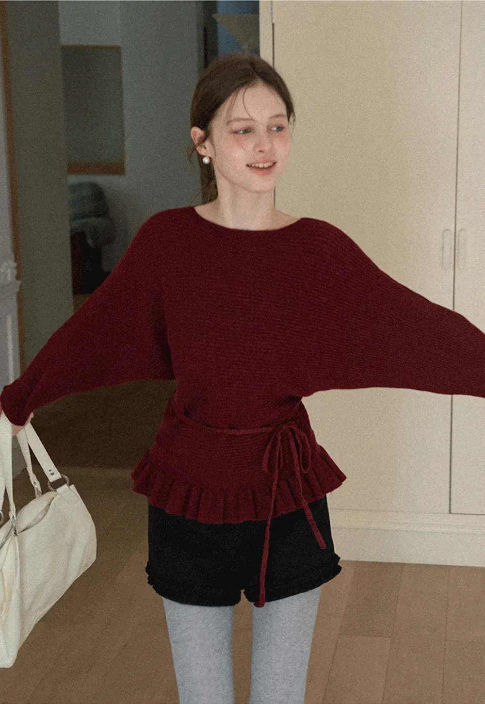 Ribbed knit sweater with tie back and flared hem design