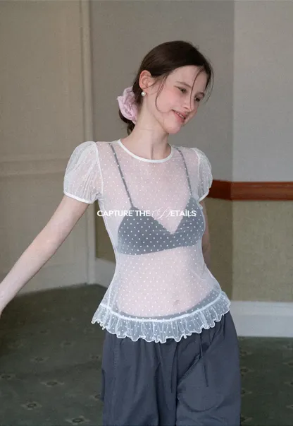 Sheer polka dot top with ruffled hem and puff sleeves