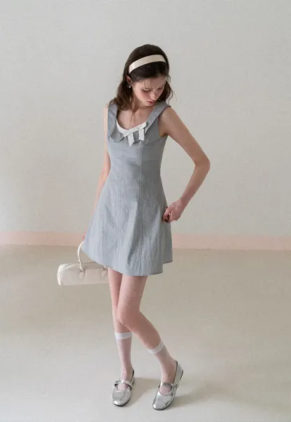 Sleeveless dress with Peter Pan collar and bow detail