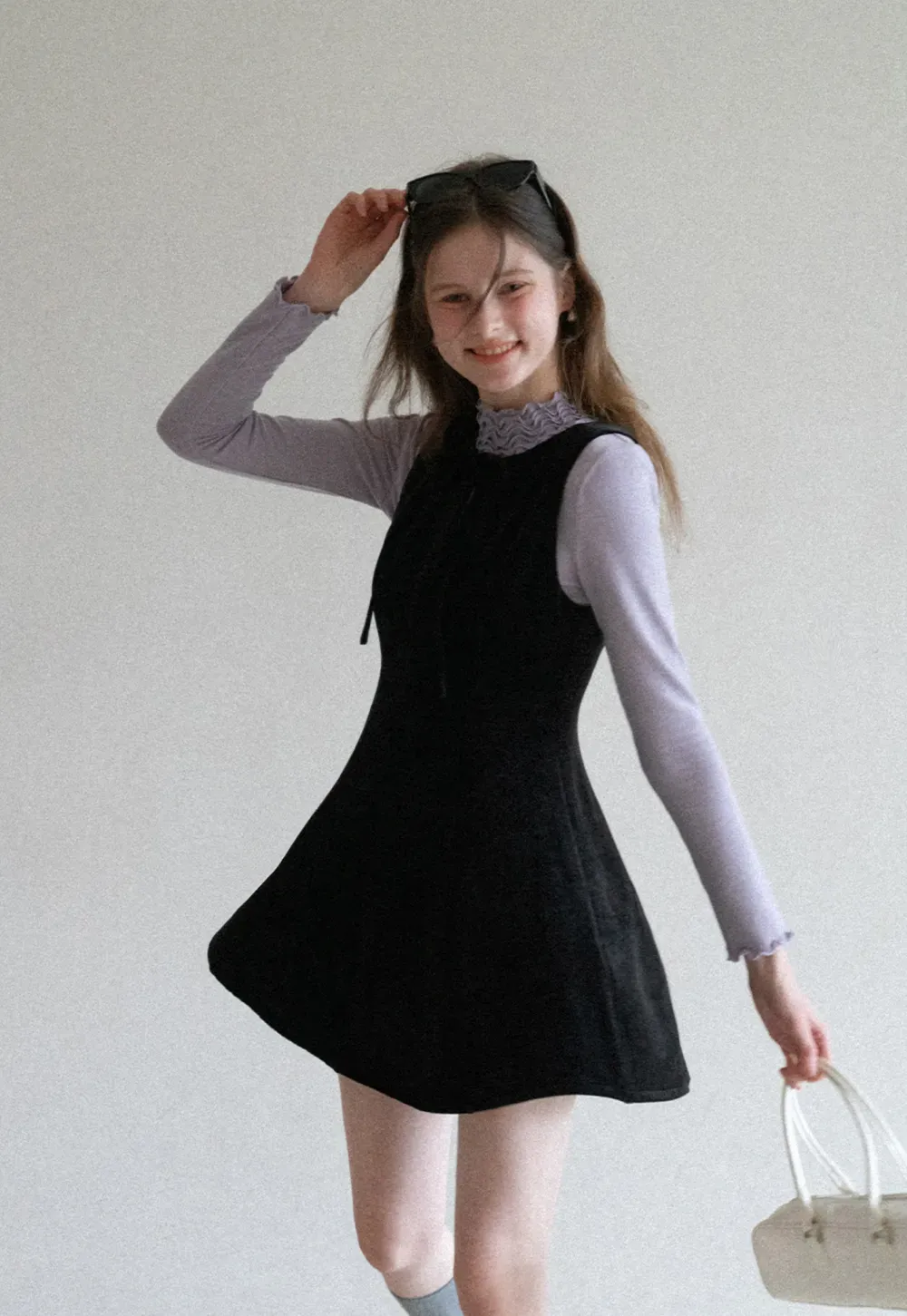 Elegant sleeveless dress with ruffled collar and bow tie design