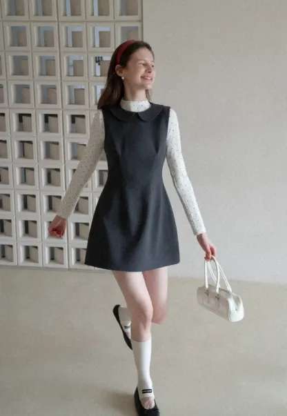 Elegant sleeveless dress with collar layered over polka dot top