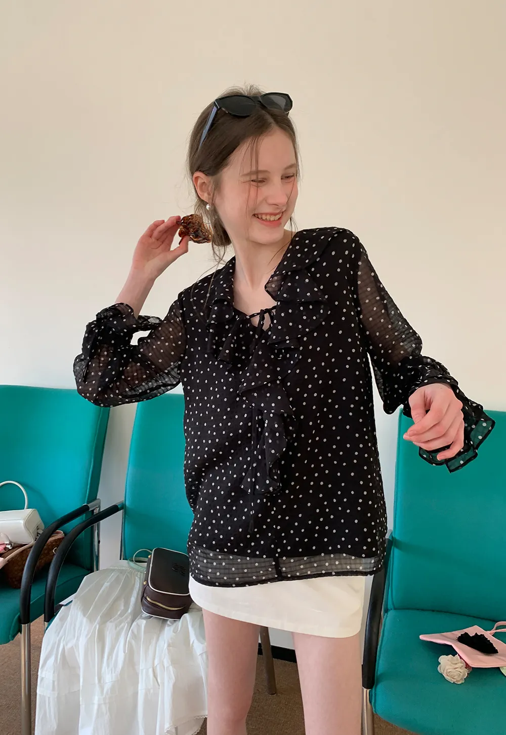 Sheer polka dot blouse with ruffled neckline and long sleeves