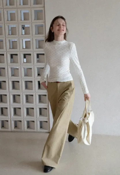 Elegant sleeveless dress with collar layered over polka dot top