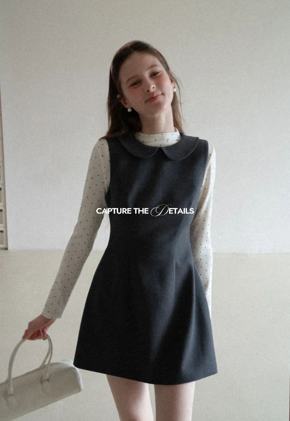 Elegant sleeveless dress with collar layered over polka dot top