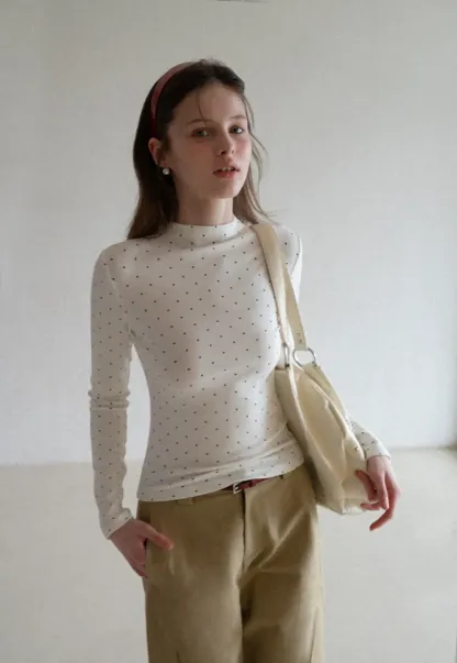 Elegant sleeveless dress with collar layered over polka dot top