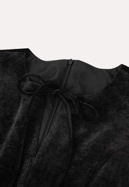 Elegant sleeveless dress with ruffled collar and bow tie design