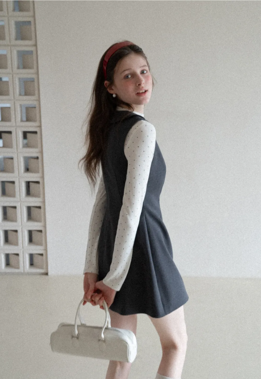 Elegant sleeveless dress with collar layered over polka dot top