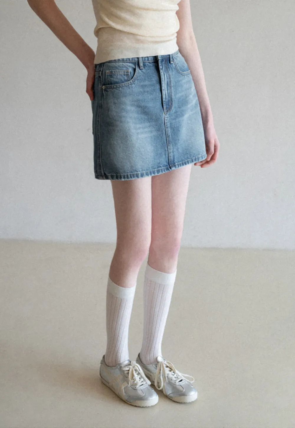 Denim mini skirt with frayed hem and front pockets