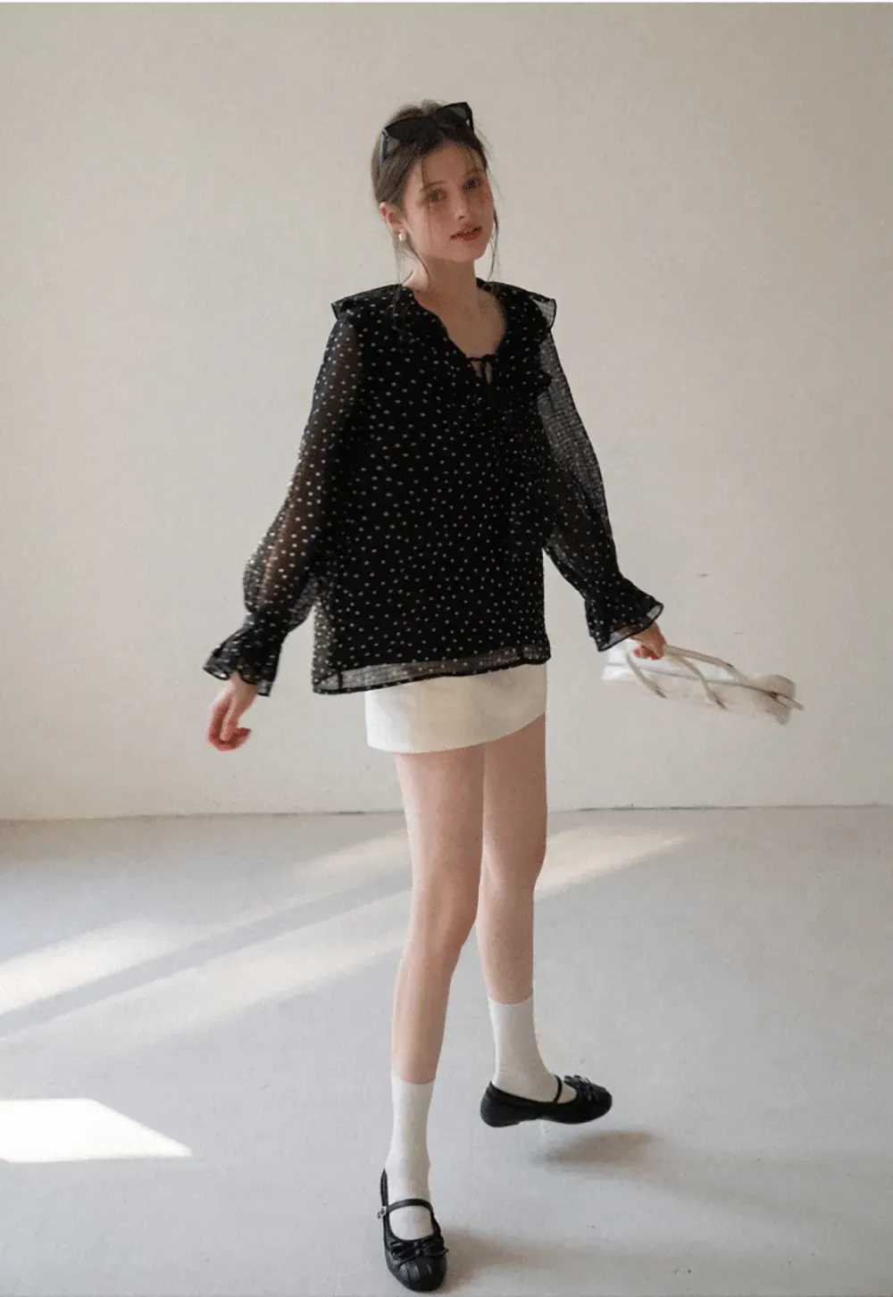 Sheer polka dot blouse with ruffled neckline and long sleeves
