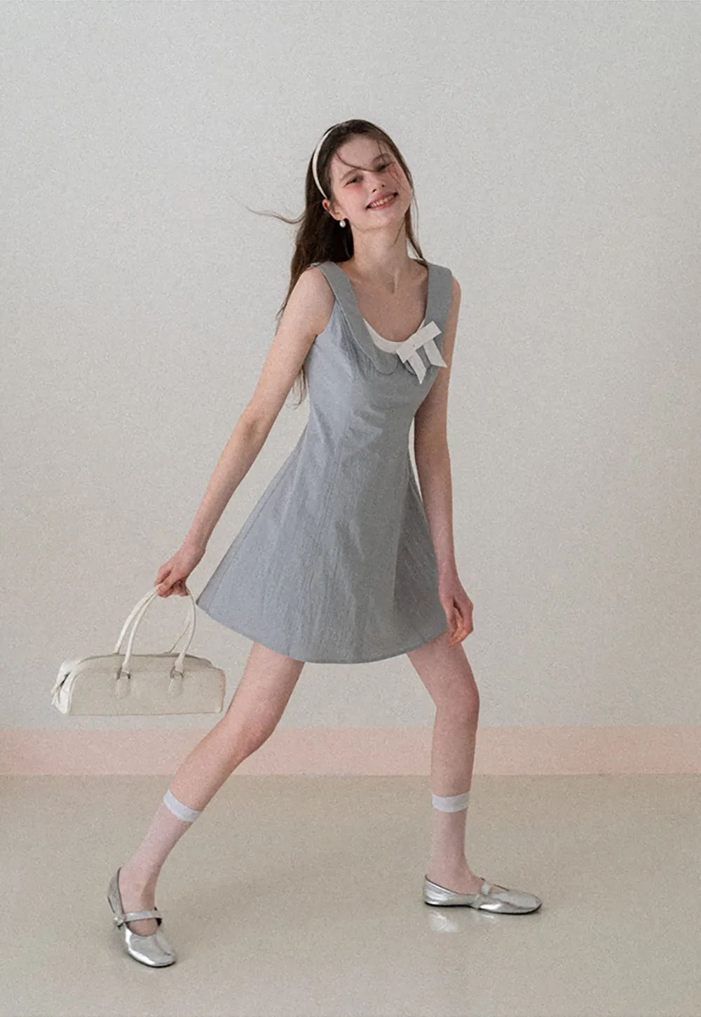 Sleeveless dress with Peter Pan collar and bow detail