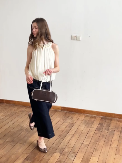 Sleeveless blouse with ruffled neckline and pleats