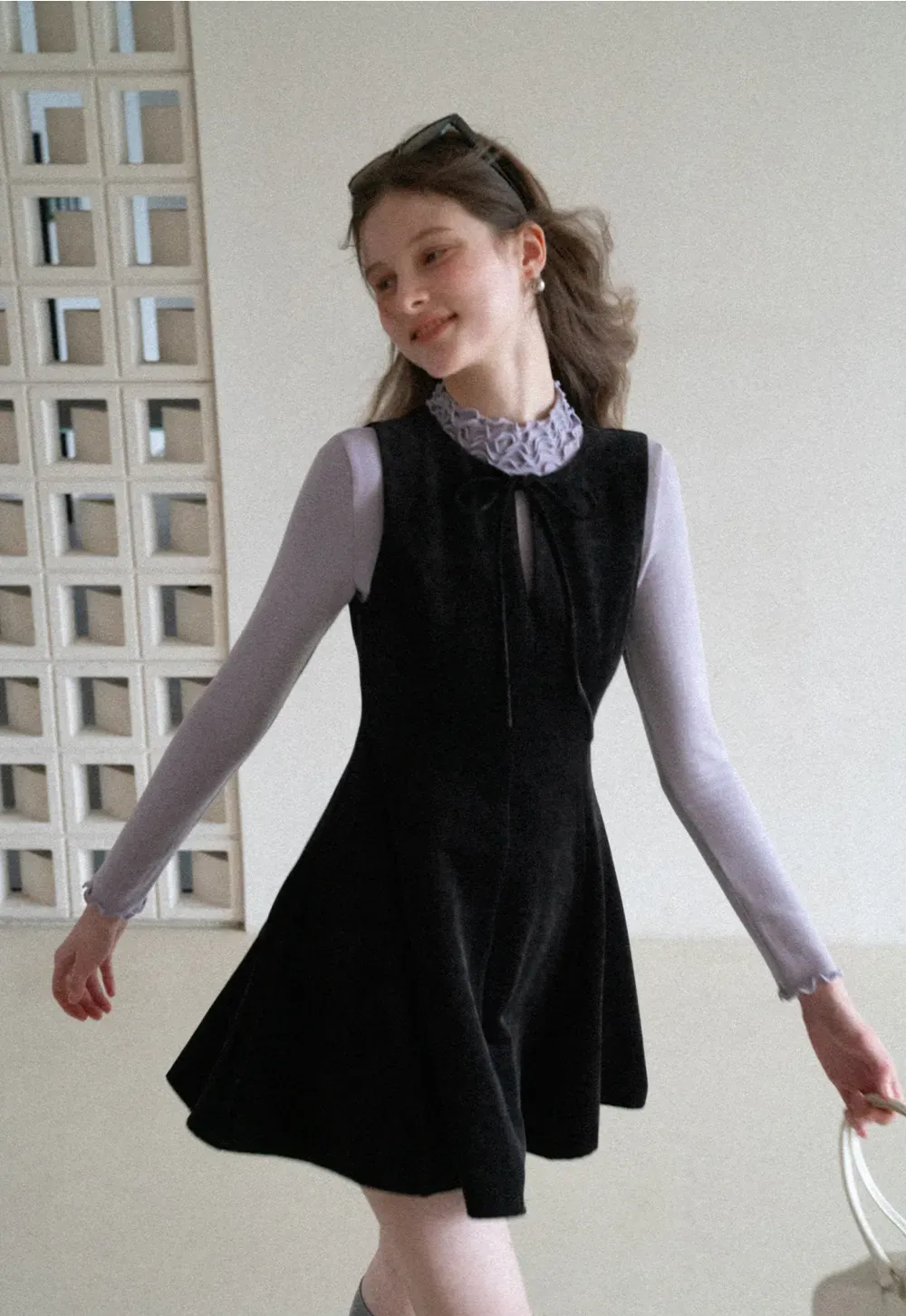 Elegant sleeveless dress with ruffled collar and bow tie design