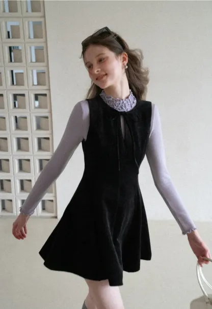 Elegant sleeveless dress with ruffled collar and bow tie design