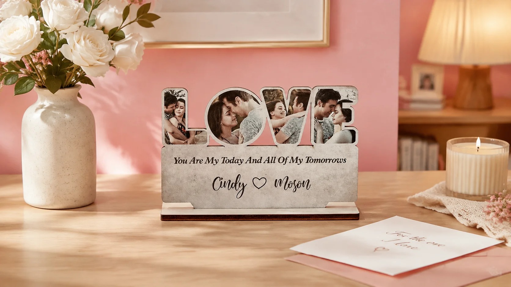 The LOVE photo plaque displayed on a wooden console table beside a ceramic vase of white roses