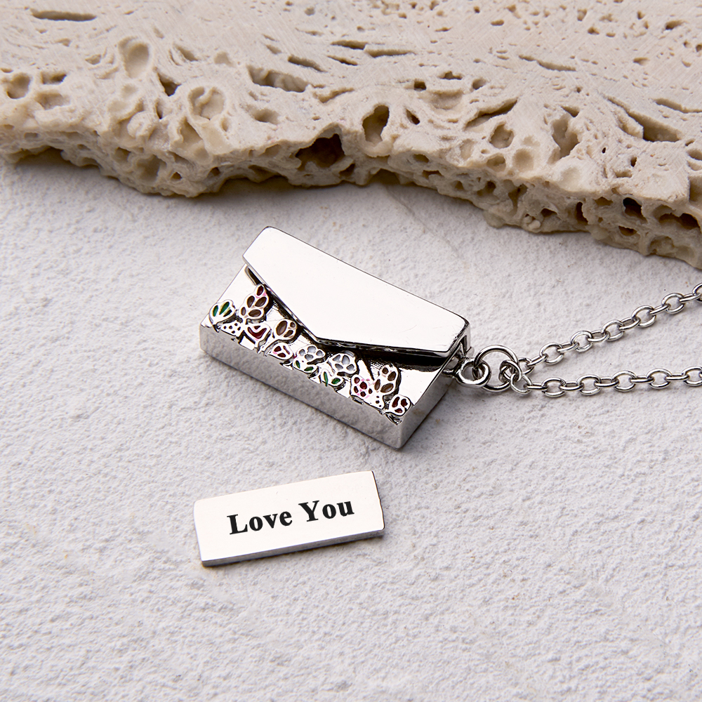 A personalized envelope necklace with custom text, displayed as a meaningful keepsake.