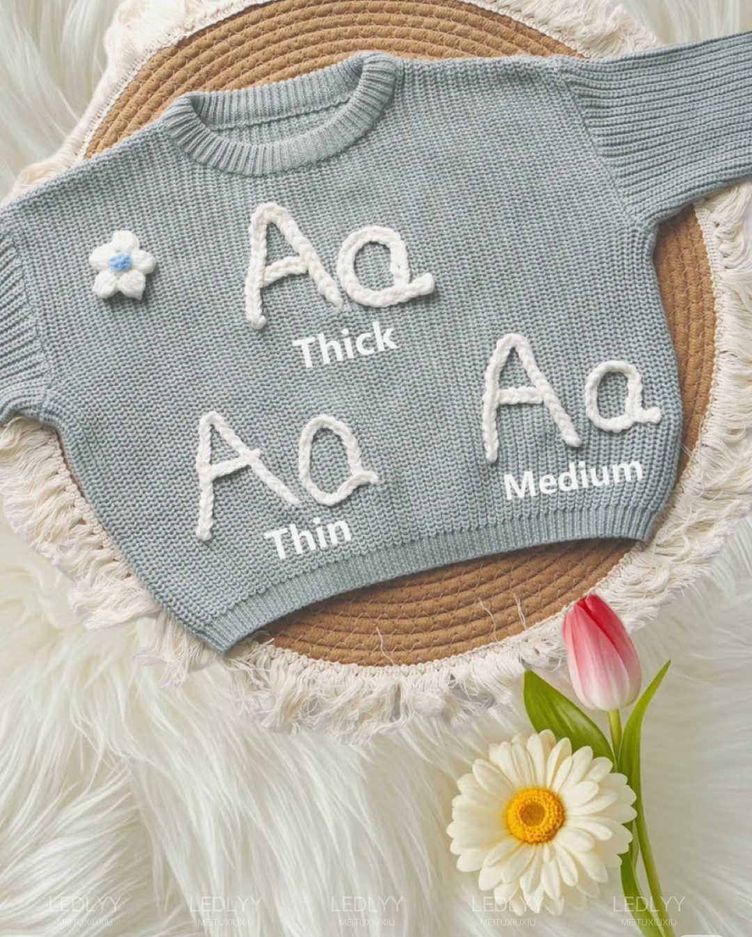 A sage green sweater showing three embroidery thread thickness samples labeled thick, medium, and thin